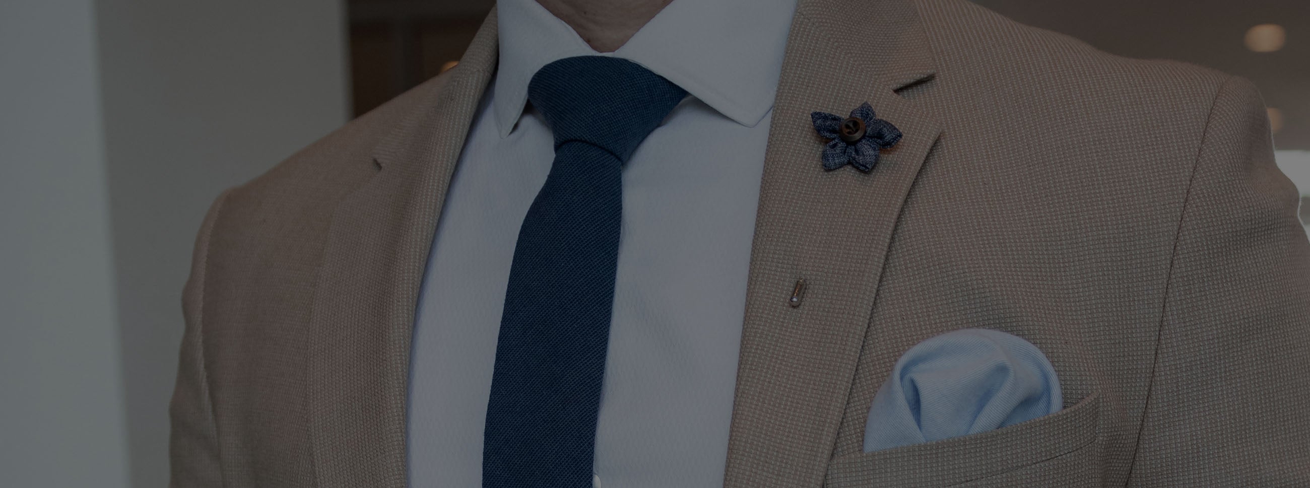 Man wearing a blue tie with a tan suit