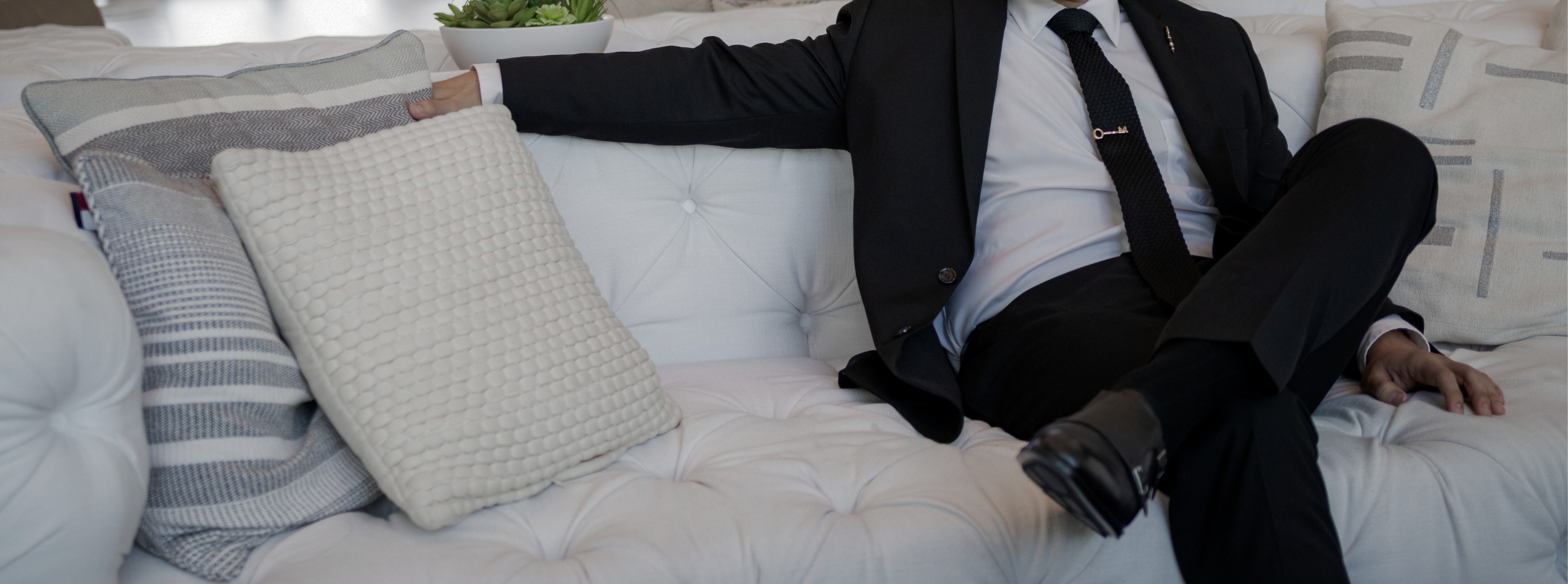 a gentleman in a black suit sitting down