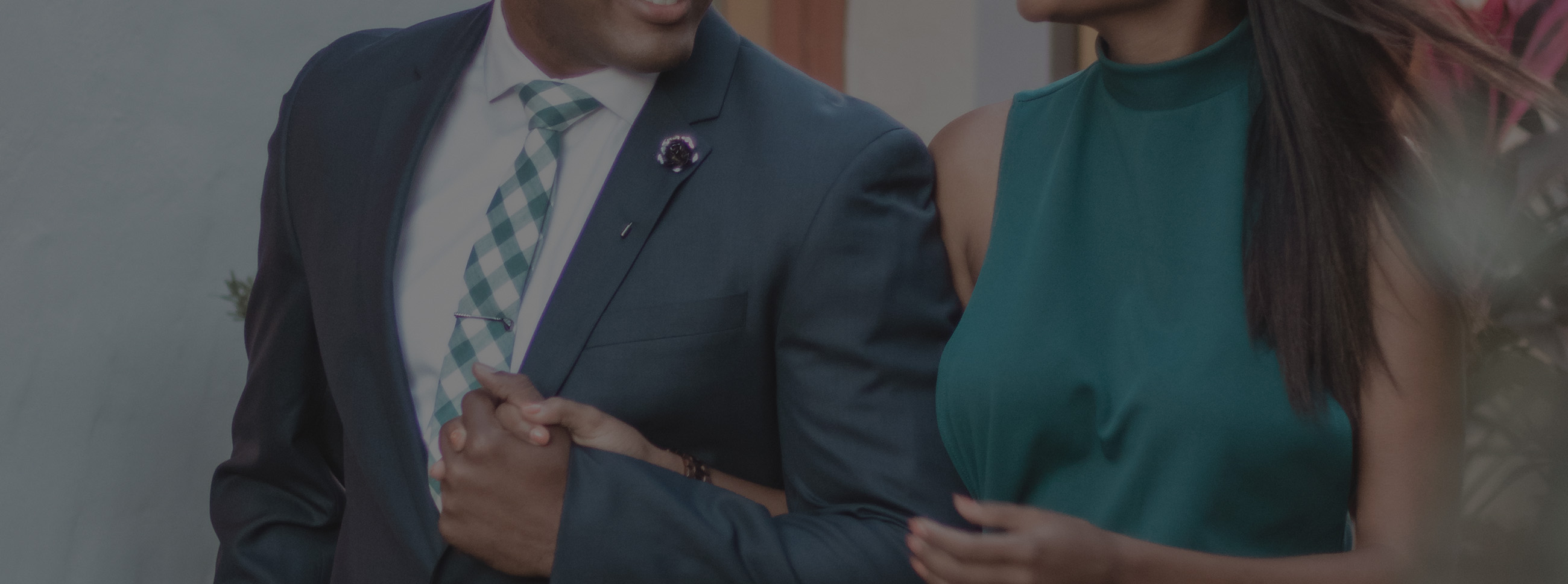 Man and woman holding hands all dressed up in a suit and tie