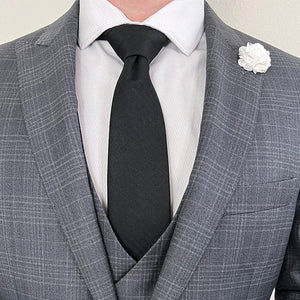 Herringbone Black Tie with a Grey plaid suit, white rose lapel pin and a white shirt