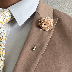 Ivory Rose Lapel Pin paired with a dark tan suit