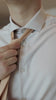 Man putting on the knitted sand tie set with a tan suit and white shirt